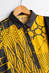 Close-up of black collar and patterned buttons on mustard geometric silk shirt