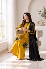 Seated view of mustard pure silk three-piece suit with black dupatta